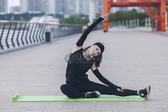 女性在户外瑜伽垫上锻炼形体图片