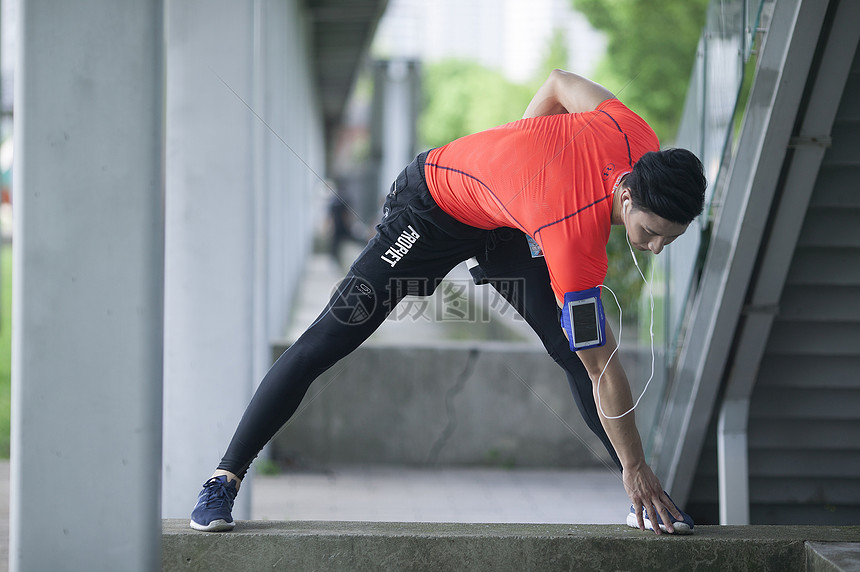 男性在户外运动场所做热身运动准备
