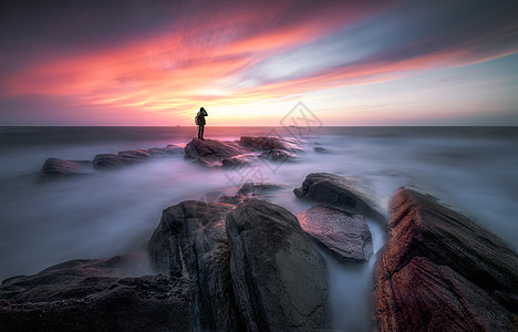 夕阳海景大海岸边的摄影人背景