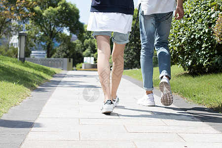 在公园散步的年轻情侣背景