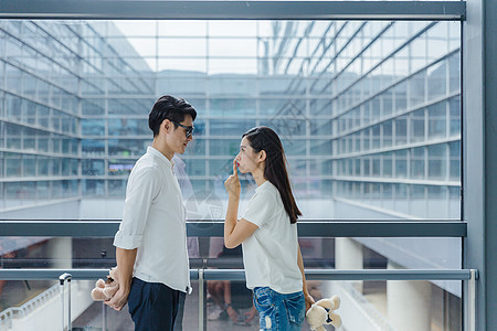 机场热恋情侣送礼物场景 背景图片