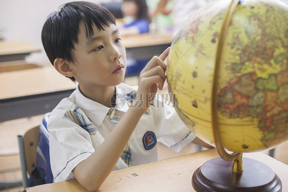 教室里男同学正在研究地球仪图片