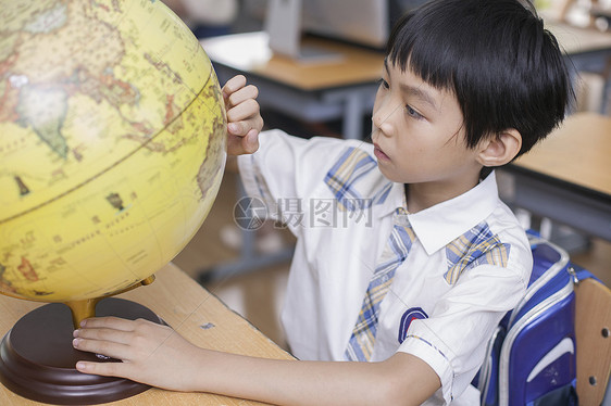 教室里男同学正在研究地球仪图片
