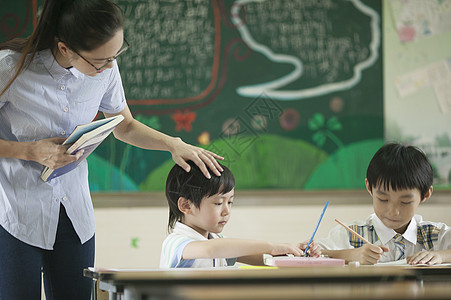 学生在上课上课时老师在辅导学生认真背景