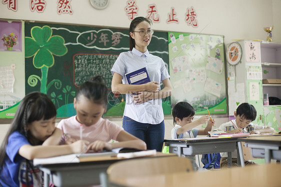 上课时老师在辅导学生认真学习图片