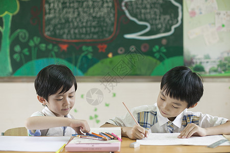 小学生男同学在教室上课做作业背景图片