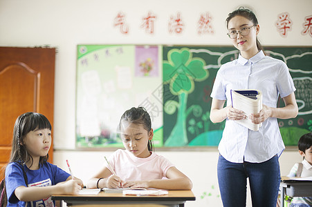 上课时老师在辅导学生认真学习图片