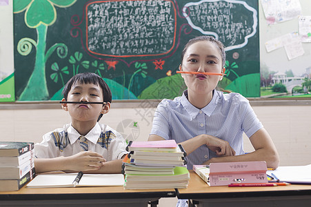 教室里女老师陪男同学学习玩耍背景图片