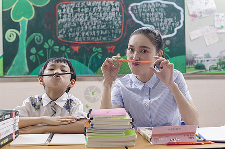 教室里女老师陪男同学学习玩耍背景图片