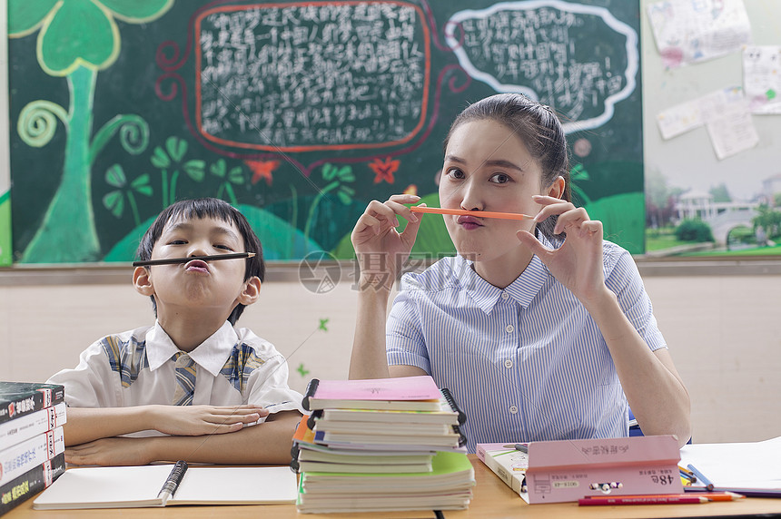 教室里女老师陪男同学学习玩耍图片