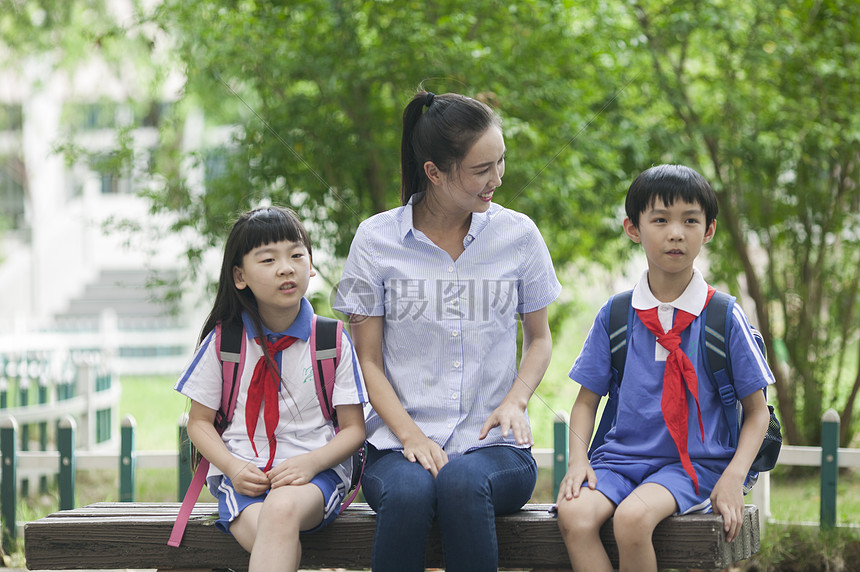 女老师和男女同学在校园里一起学习图片