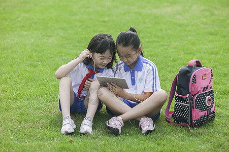 远程教育女同学在学校里草坪上用ipad 学习背景