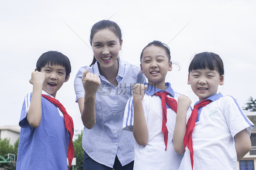 女老师和男女同学在学校操场上一起加油图片