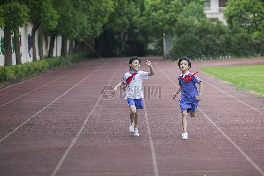 男女同学在操场跑道上比赛跑步