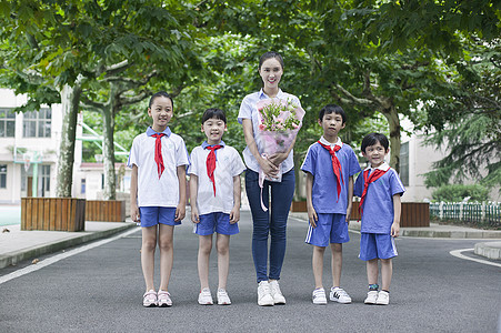 教师节男女同学们和女老师在校园里给老师献花高清图片