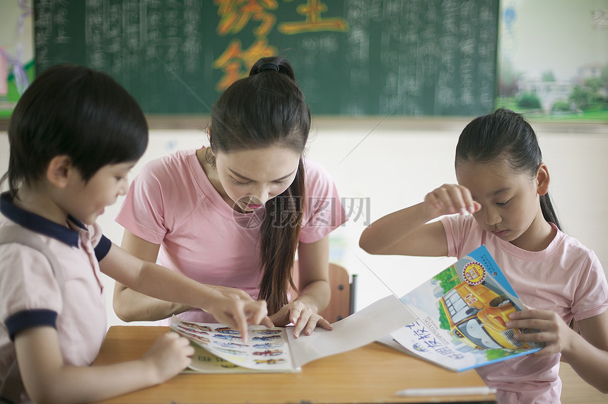 男女同学和女老师在教室里一起看书图片