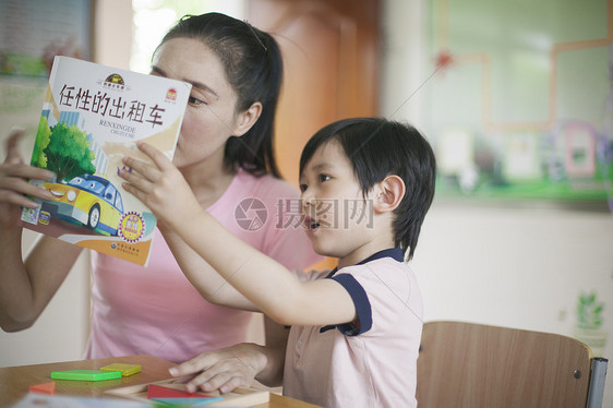 男同学和女老师在教室里一起看书图片