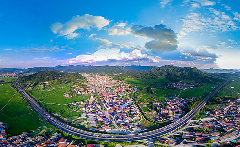 蓝天眺望航拍高速公路穿过村镇背景