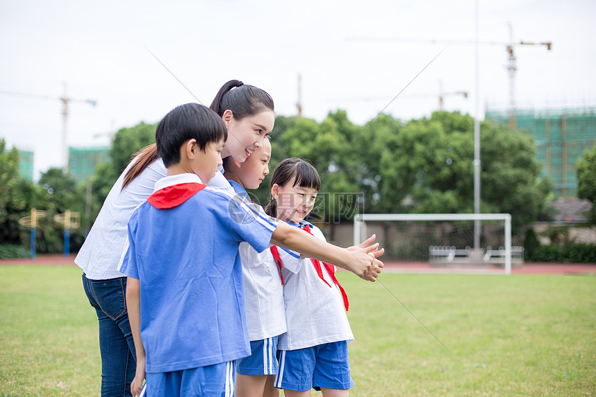 老师带着同学们草坪上玩游戏