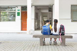 在树下坐着一起看书的小学生图片