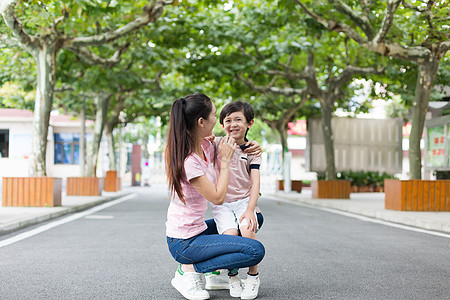 学校里的路妈妈学校里接孩子放学下课背景