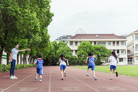 男教师儿童教育老师看孩子们在操场上奔跑背景