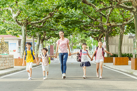 感恩日教师节老师牵着学生们上学背景