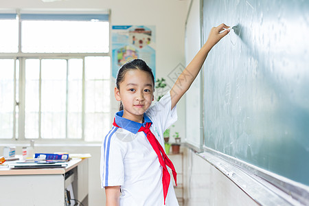 在黑板上写板书的小学生背景图片