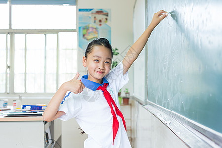 在黑板上写板书的小学生背景图片