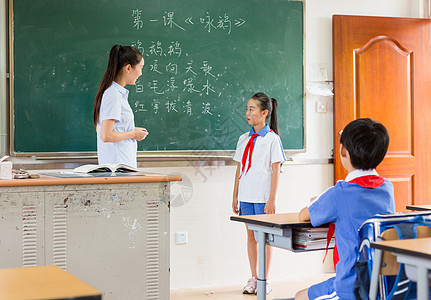 站在教室黑板前思考问题的小学生图片