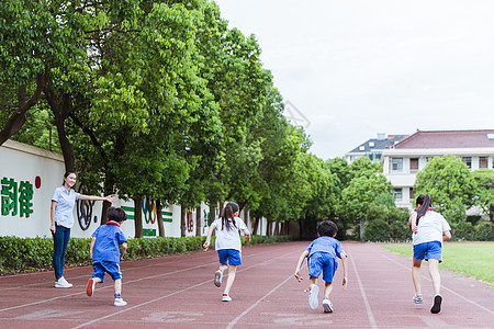 一群女生老师看孩子们在操场上奔跑背景