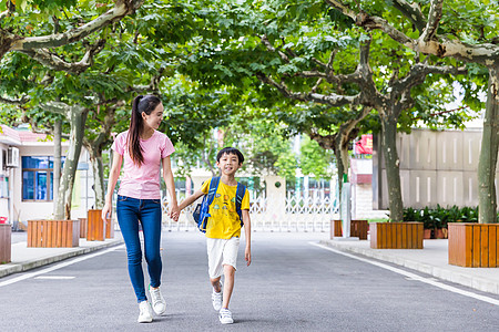 校园亲子妈妈牵着儿子上学高清图片