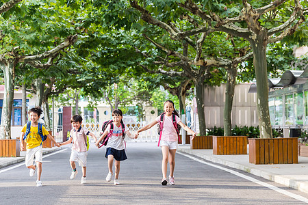 阳光下孩子们牵手快乐的奔跑同学高清图片素材