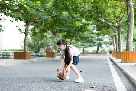 校园林荫道上打篮球的小学生女生高清图片