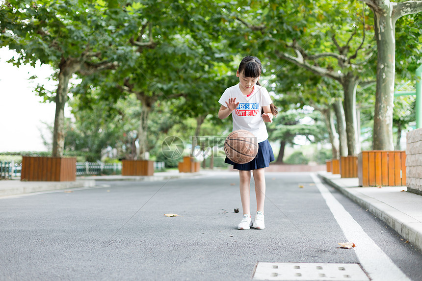 校园林荫道上打篮球的小学生女生