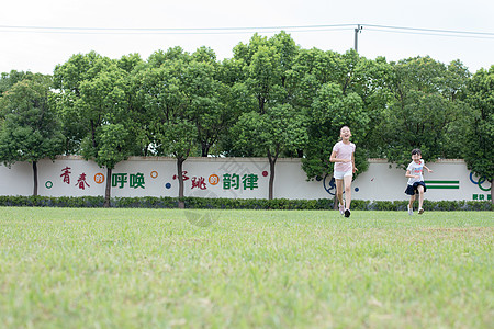 在操场草坪一起玩耍奔跑的小学生图片