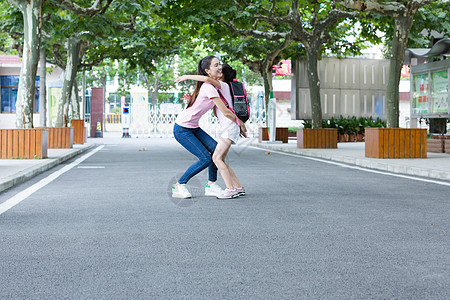 小学生背着书包放学后的孩子跑向妈妈的怀抱背景