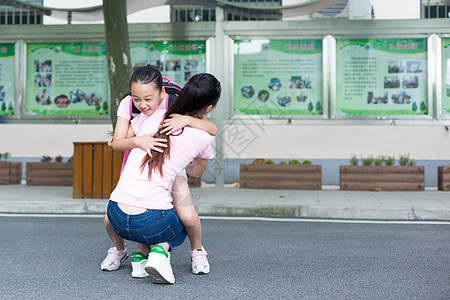 学生放学后的孩子跑向妈妈的怀抱背景