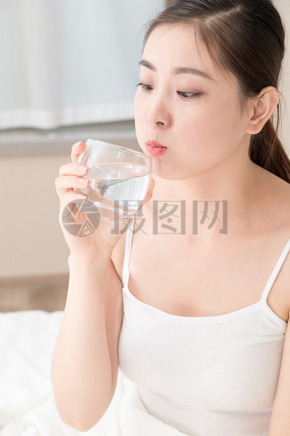 坐在床上喝水的年轻美女图片