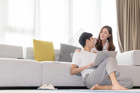 情侣在家看电脑情侣在家客厅一起休闲放松网购购物背景