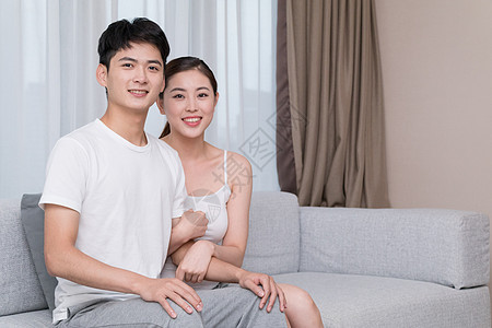 年轻夫妻坐在客厅沙发上图片