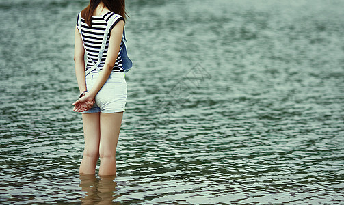 低头美女站在水里的女孩意境图背景