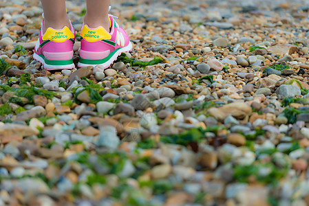 彩色洞洞鞋彩色石滩上的鞋背景