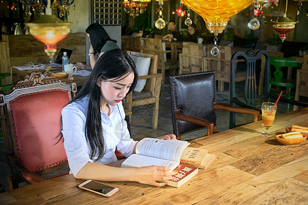 咖啡厅灯咖啡厅看书的年轻女生背景