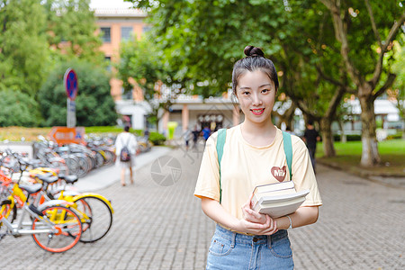 亚洲大学大学校园内女生抱着书本背景