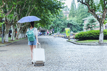 下雨天女生拉旅行箱背影高清图片