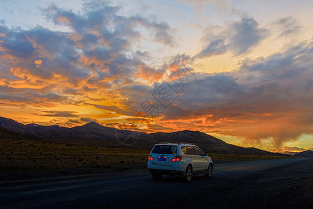 夕阳下行驶在公路上的汽车背景图片