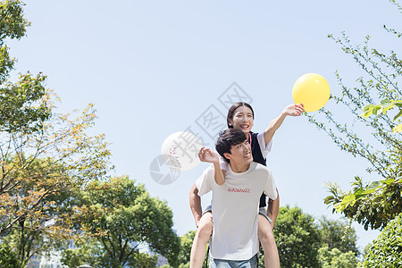 男生背着女生一起游玩旅行背景