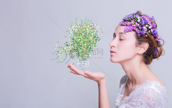 女人手托蝴蝶花卉绿叶灯泡图片