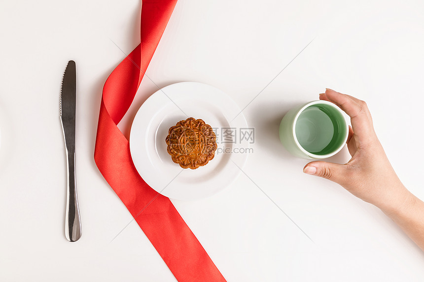 中秋佳节月饼与手拿茶饮图片